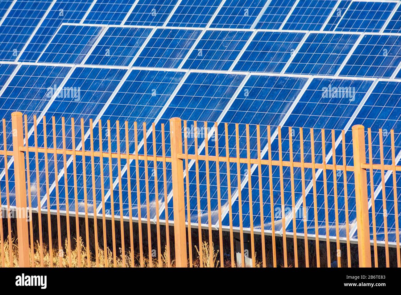 La barrière de sécurité empêche l'accès non autorisé au système et à l'installation de production d'énergie solaire électrique. La surface poussiéreuse des panneaux solaires nécessite un entretien Banque D'Images