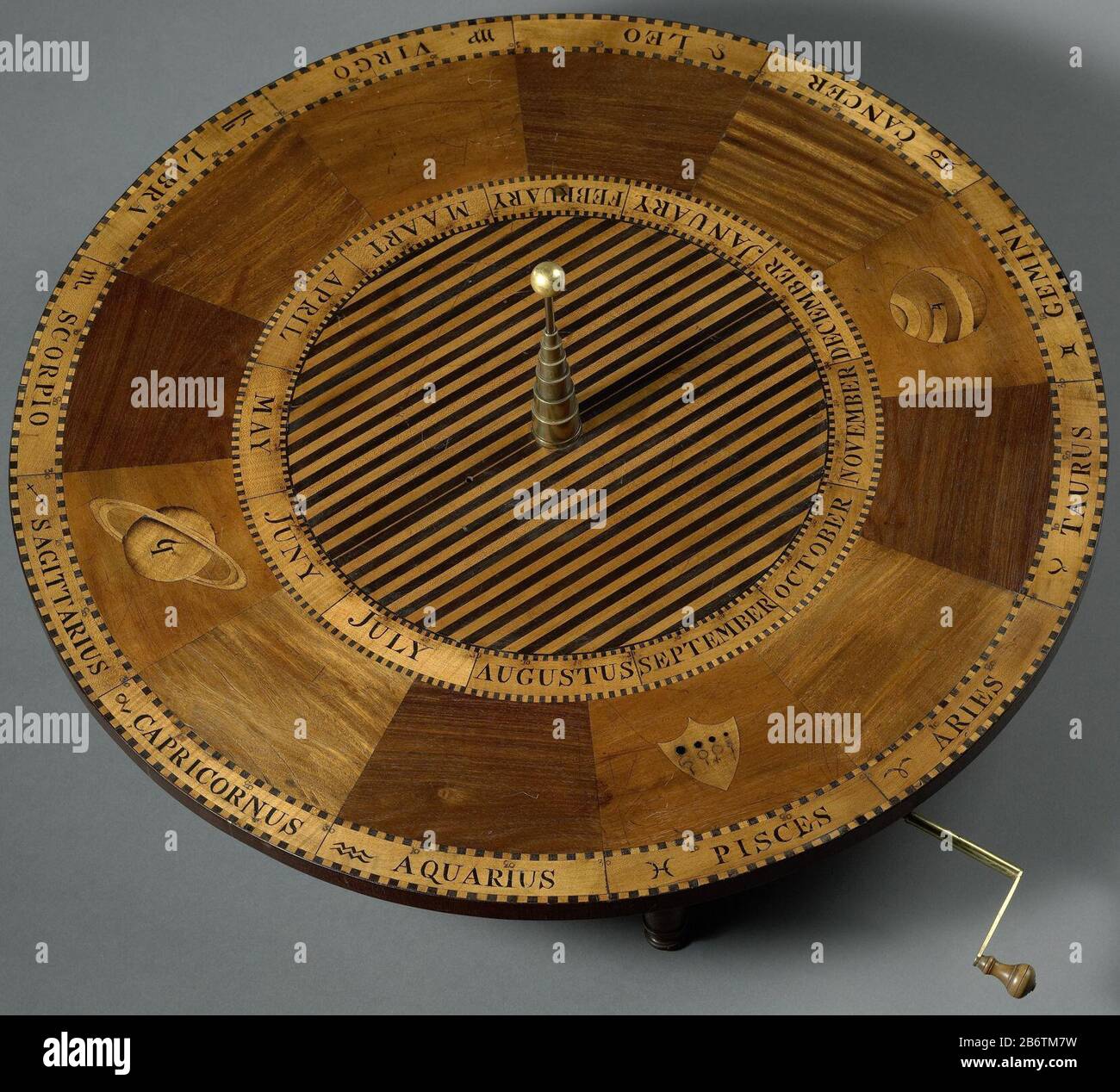 Het onderstel van het planétarium, tellure, lunarium dispositif Où: Le long du mouvement du soleil, de la terre, de la lune et des planètes peuvent être visualisés. Le châssis est une table sur quatre jambes courtes sous le plateau de la table avec un train d'engrenages en laiton à partir duquel une tige projette vers laquelle une manivelle (-4) peut être poussée. Sur le plan de table se trouvent les noms et symboles des constellations et les douze mois. Centrent un trépied à bande par paliers. À cela fait partie du soleil (une ampoule plaquée or: -5) . Fabricant: Fabricant d'instruments: Hartog Launplaats de fabrication: Amsterdam Dating: CA. 1800 - env. 1808 matériau : rosewoo ivoire de laiton Banque D'Images