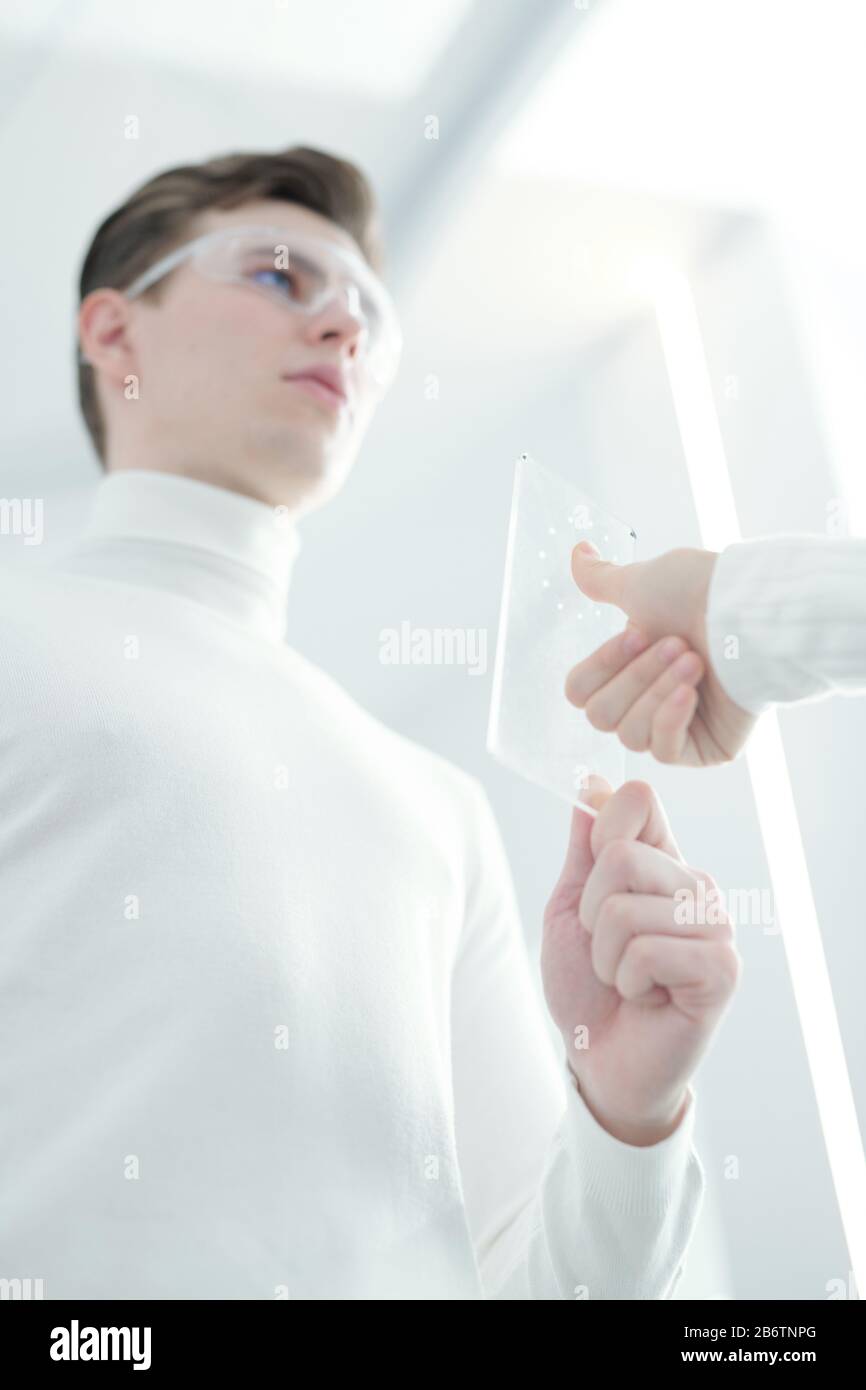 Vue ci-dessous du jeune homme tenant un lecteur d'authentification d'empreintes digitales et vérifiant l'empreinte digitale de la femme Banque D'Images