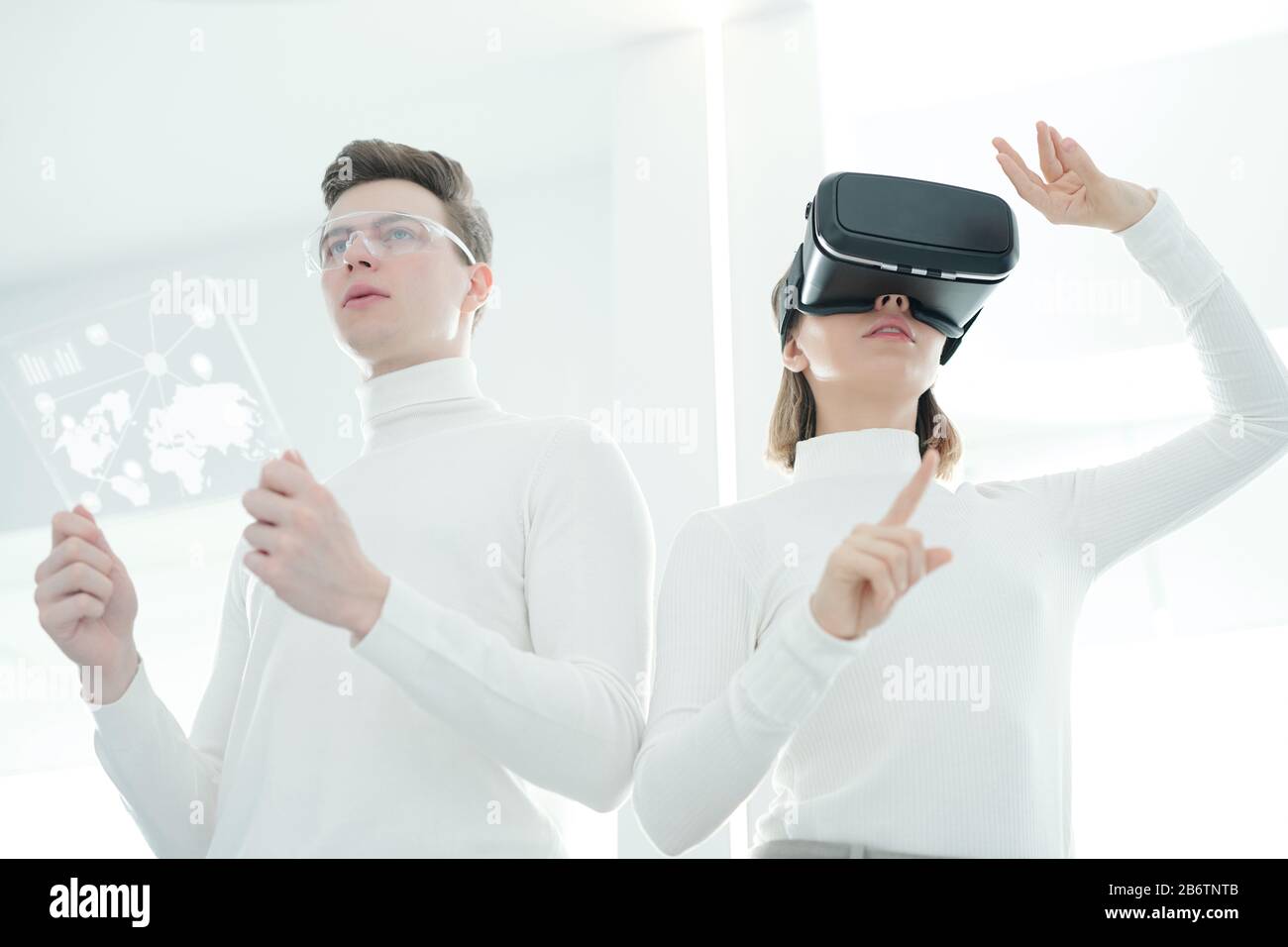 Vue ci-dessous des jeunes développeurs synchronisant le simulateur de réalité virtuelle et la tablette futuriste Banque D'Images