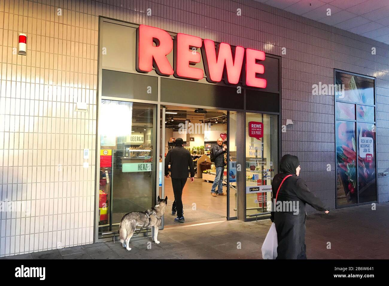 Munich, Allemagne. 11 mars 2020. Les clients et un chien en laisse devant un supermarché REWE, une succursale, Lebensswittel, entrée, logo de la société, @Sven Simon Fotoagentur GmbH & Co. Pressefeto KG # Prinzess-Luise-Str. 41 # 45479 M uelheim/R uhr # Tél 0208/9413250 # Fax. 0208/9413260 # GLS Bank # BLZ 430 609 67 # Kto. 4030 025 100 # IBAN DE75 4306 0967 4030 0251 00 # BIC GENODEM1GLS # WWW.SVENSIMON.NET. | utilisation dans le monde crédit: DPA/Alay Live News Banque D'Images