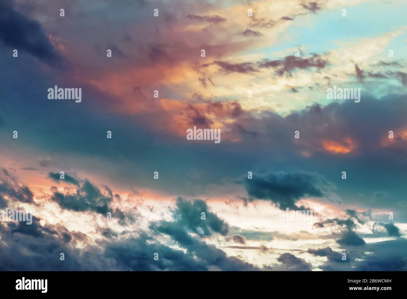 Magnifiques nuages spectaculaires dans le ciel peints dans des couleurs vives juteuses au coucher du soleil. Arrière-plan abstrait clair et nuageux Banque D'Images