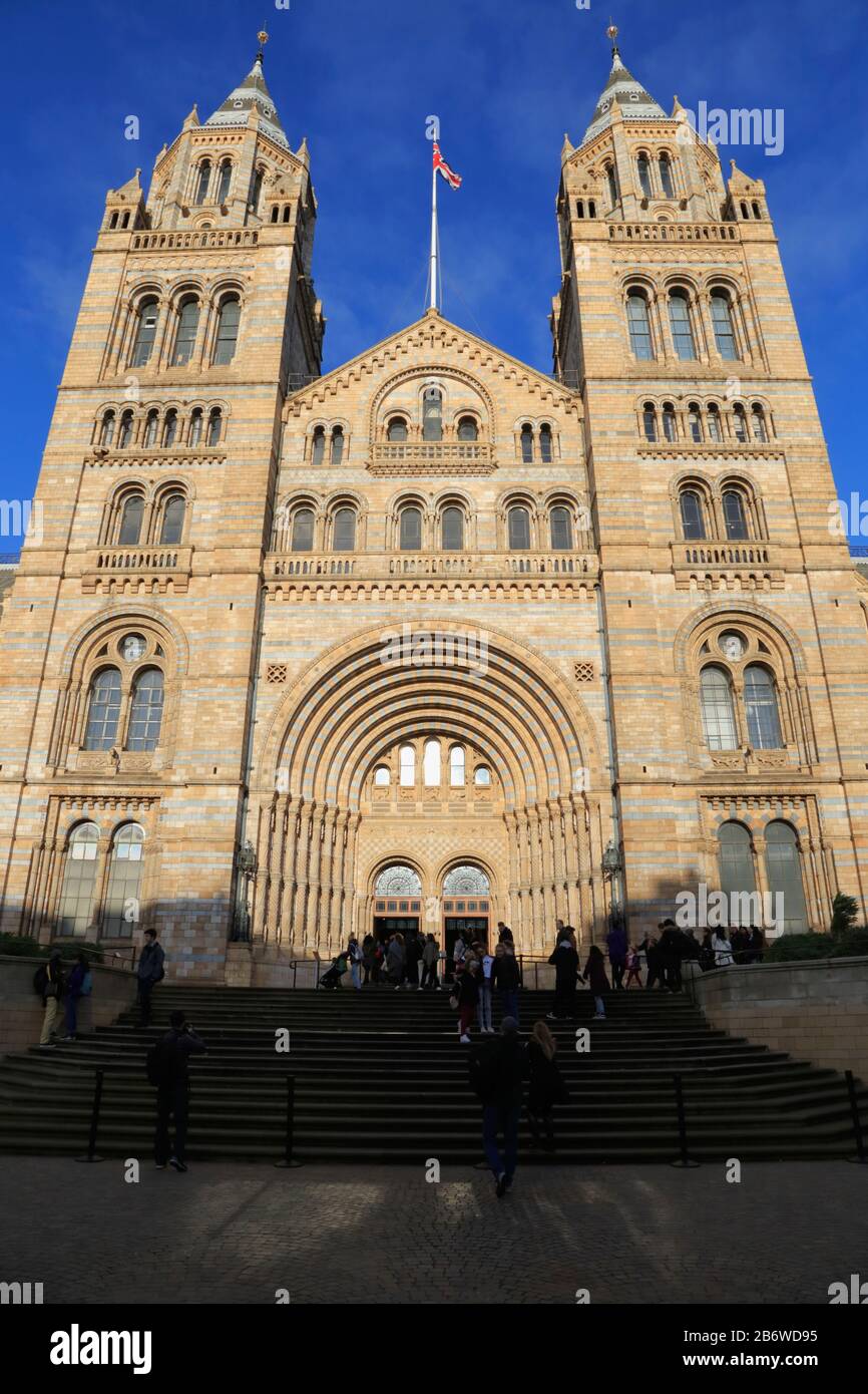 Les gens en dehors de l'entrée et de la façade du Natural History Museum à South Kensington, Londres, Royaume-Uni. Le bâtiment ressemble à une grande cathédrale. Banque D'Images