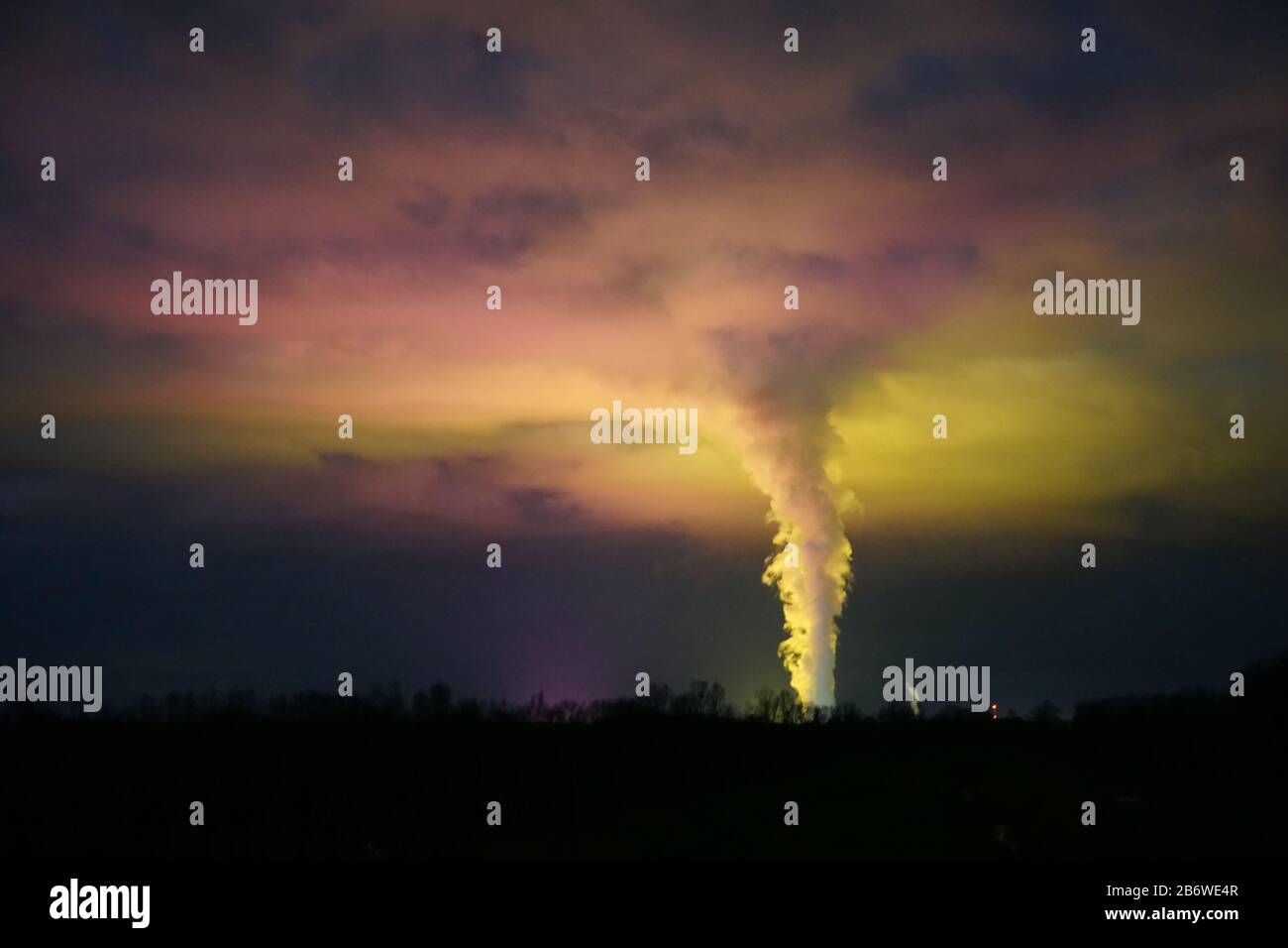 lumière surréaliste des maisons vertes dans le ciel nocturne avec la vapeur qui monte de la centrale nucléaire Banque D'Images