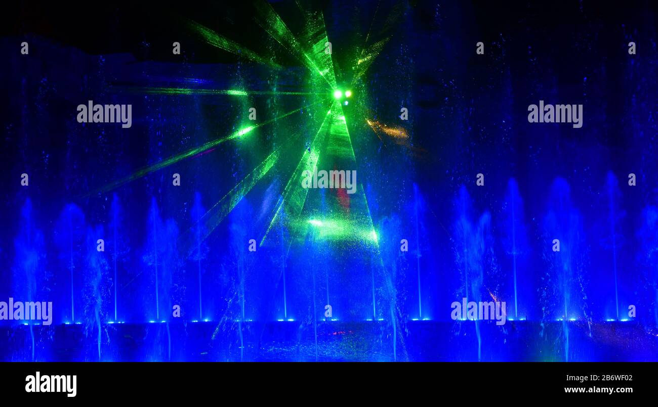 Fontaines d'eau colorées. Magnifique spectacle laser et fontaines. Grand spectacle de fontaine lumineuse à jet d'eau de danse décoratif multicolore la nuit. Sombre Banque D'Images