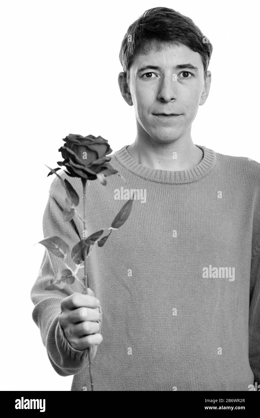 Studio shot of man holding red rose Banque D'Images