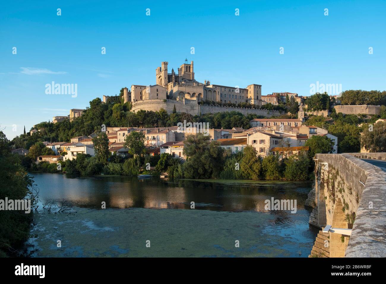 Europe, France, Occitanie. L'église Saint-Nazaire et le vieux pont de la ville fortifiée de Béziers sur un promontoire au-dessus de l'Orbe Banque D'Images