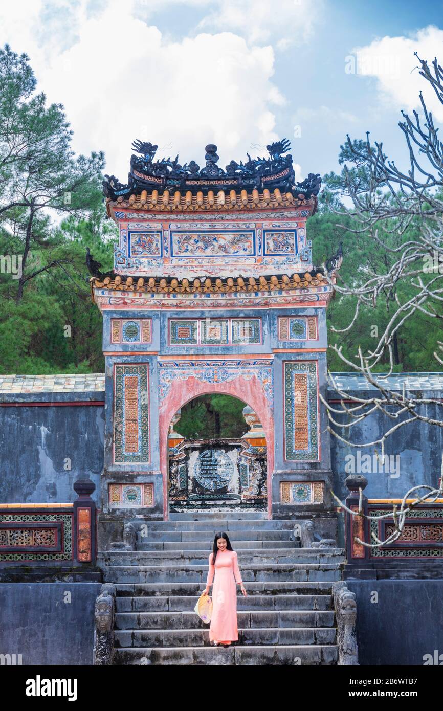 Vietnam, ville historique de Hue. Une jeune femme vietnamienne dans une robe Ao Dai traditionnelle au mausolée du Temple du roi Tu Duc Nguyen Banque D'Images