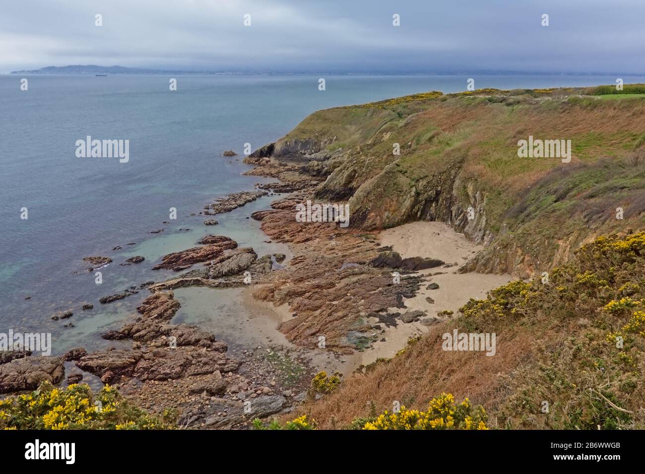 Falaises rocheuses et plage le long de la côte nord de la mer de howth, Dublin, irlande par jour nuageux, Banque D'Images