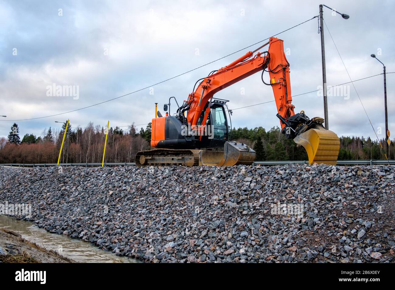 Gros plan des pelles hydrauliques industrielles travaillant sur le chantier de construction de routes. Banque D'Images