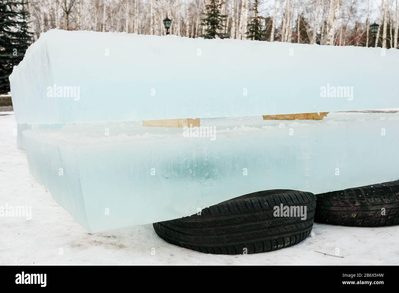 Glace pour la construction d'une ville de glace. Pneu noir en position debout. Briques de glace Banque D'Images Glace pour la construction d'une ville de glace. Pneu noir en position debout. Briques de glace Banque D'Images