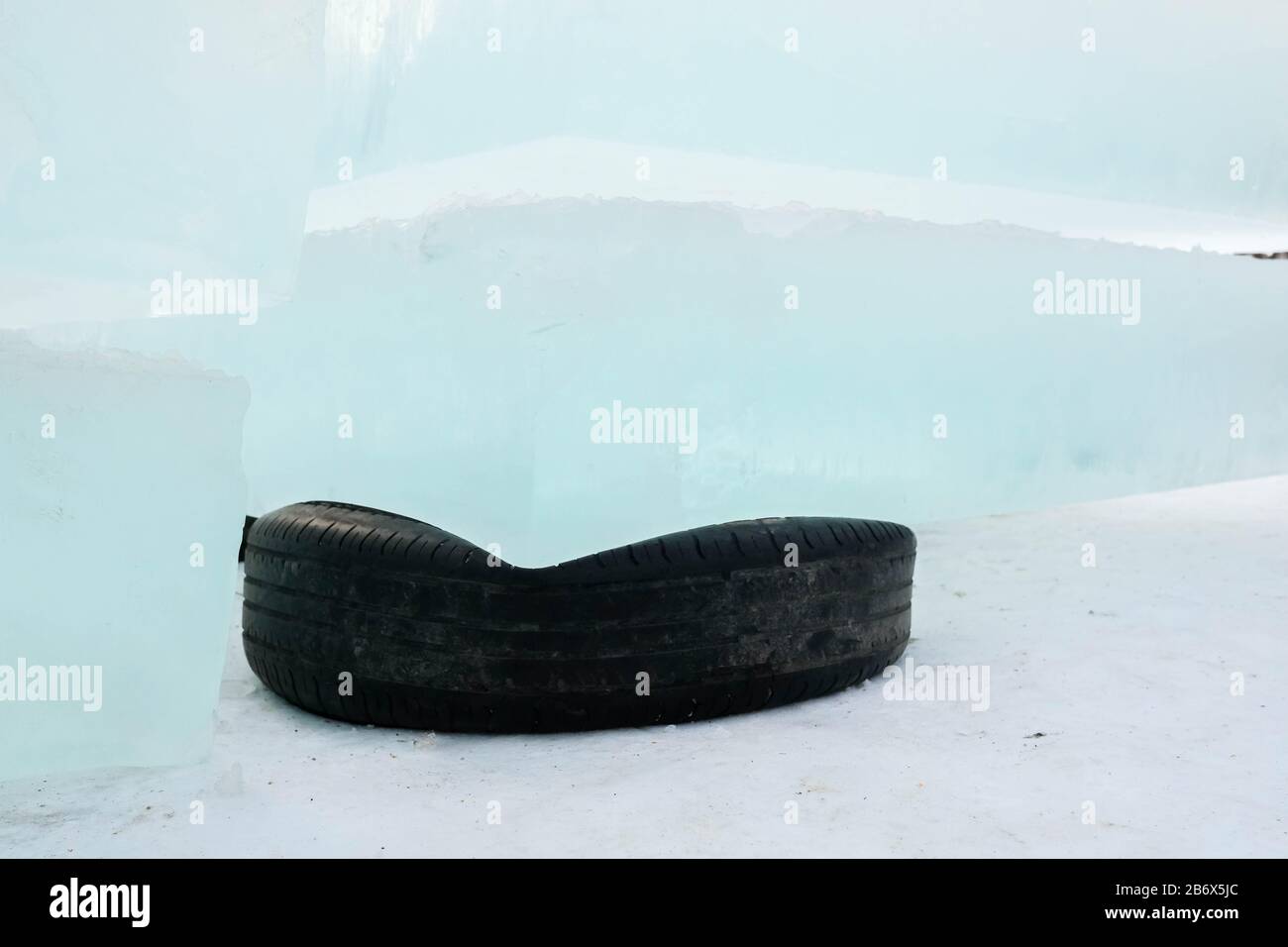 Les blocs de glace se trouvent sur les pneus en caoutchouc. Pneus noirs en tant que support. Glace pour construire une ville de glace Banque D'Images Les blocs de glace se trouvent sur les pneus en caoutchouc. Pneus noirs en tant que support. Glace pour construire une ville de glace Banque D'Images