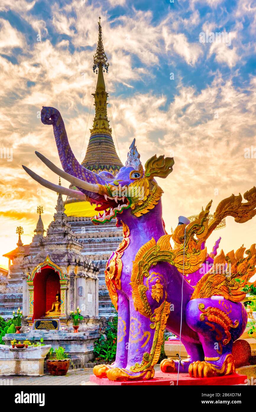 Éléphant violet venillé devant le chedi de Wat Chetawan au coucher du soleil, Chiang Mai, Thaïlande Banque D'Images Éléphant violet venillé devant le chedi de Wat Chetawan au coucher du soleil, Chiang Mai, Thaïlande Banque D'Images
