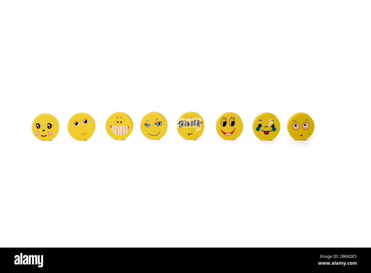 Quelques disques ronds jaunes avec des visages drôles sur le fond blanc. Espace de copie. Isolé Banque D'Images