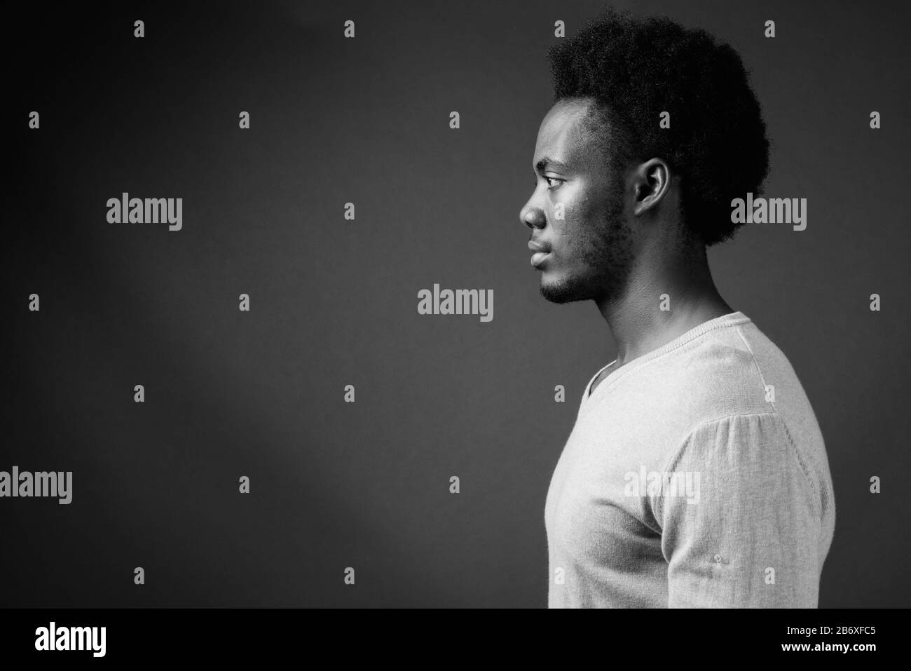 Beau jeune homme africain contre l'arrière-plan gris Banque D'Images