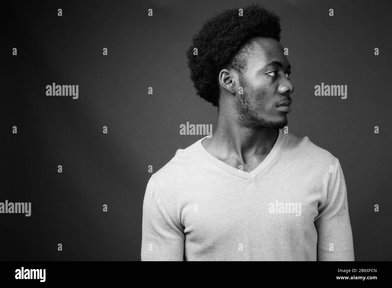 Beau jeune homme africain contre l'arrière-plan gris Banque D'Images