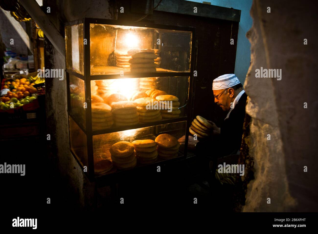 Un boulanger met du pain dans un présentoir à Fes, au Maroc Banque D'Images
