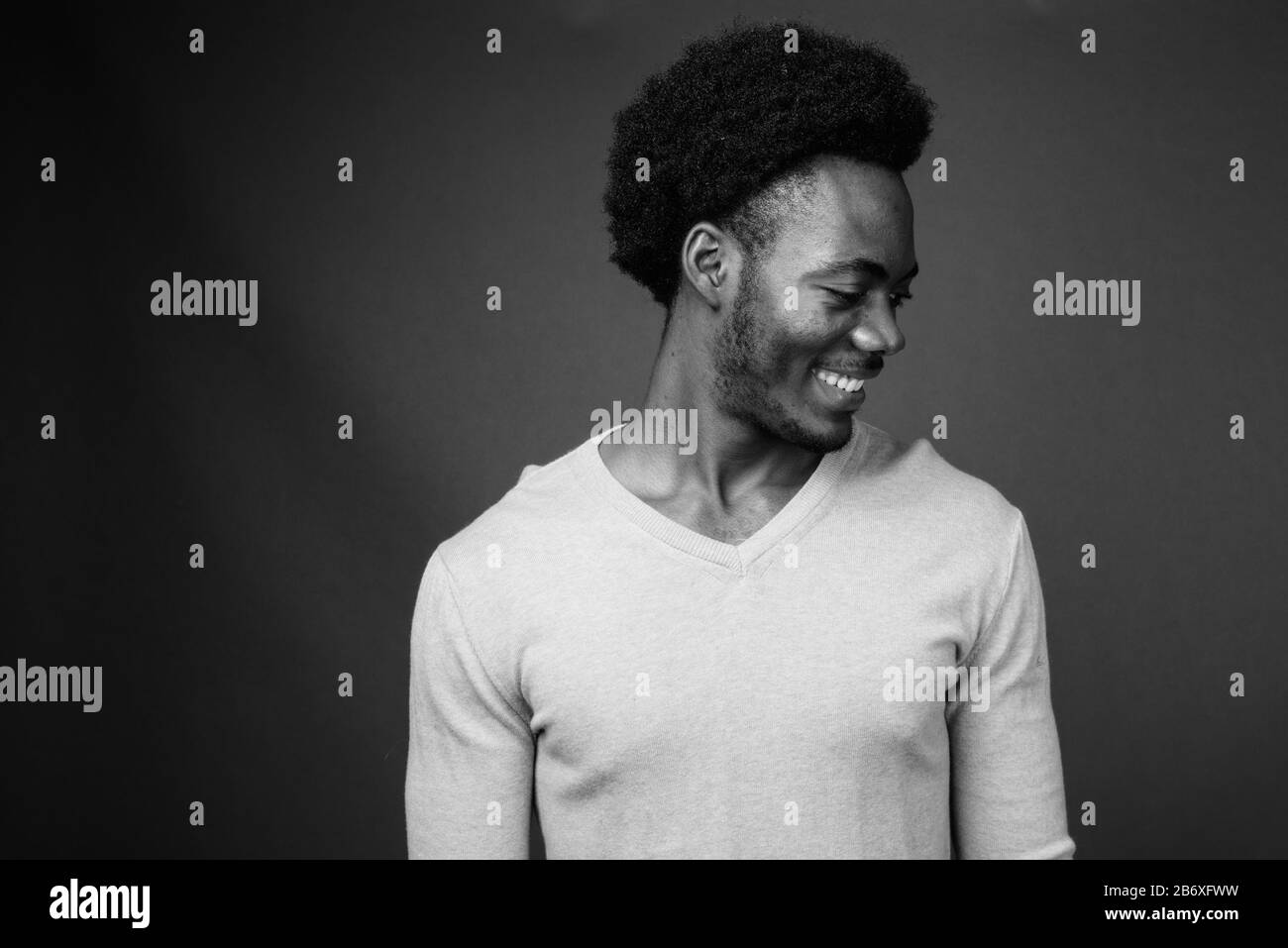 Beau jeune homme africain contre l'arrière-plan gris Banque D'Images
