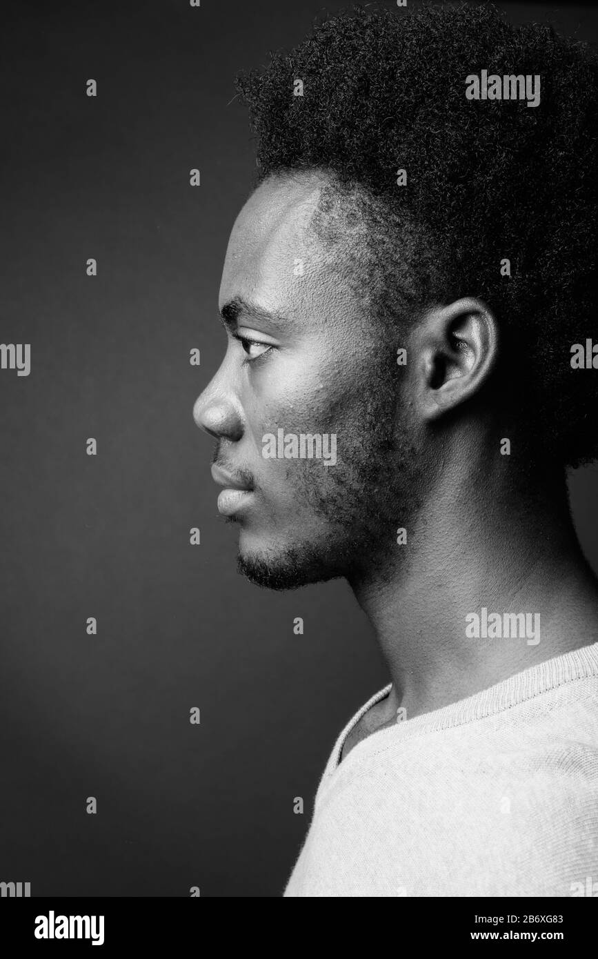 Beau jeune homme africain contre l'arrière-plan gris Banque D'Images