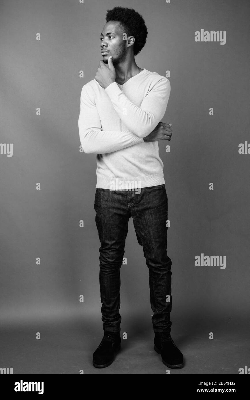 Beau jeune homme africain contre l'arrière-plan gris Banque D'Images