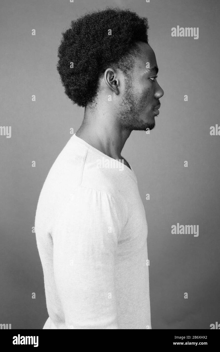 Beau jeune homme africain contre l'arrière-plan gris Banque D'Images