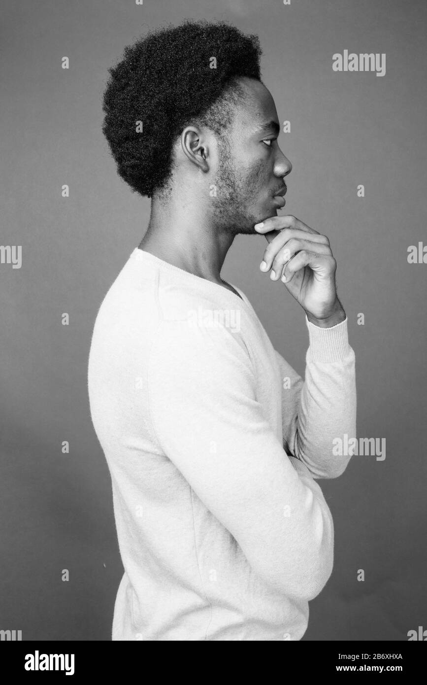 Beau jeune homme africain contre l'arrière-plan gris Banque D'Images
