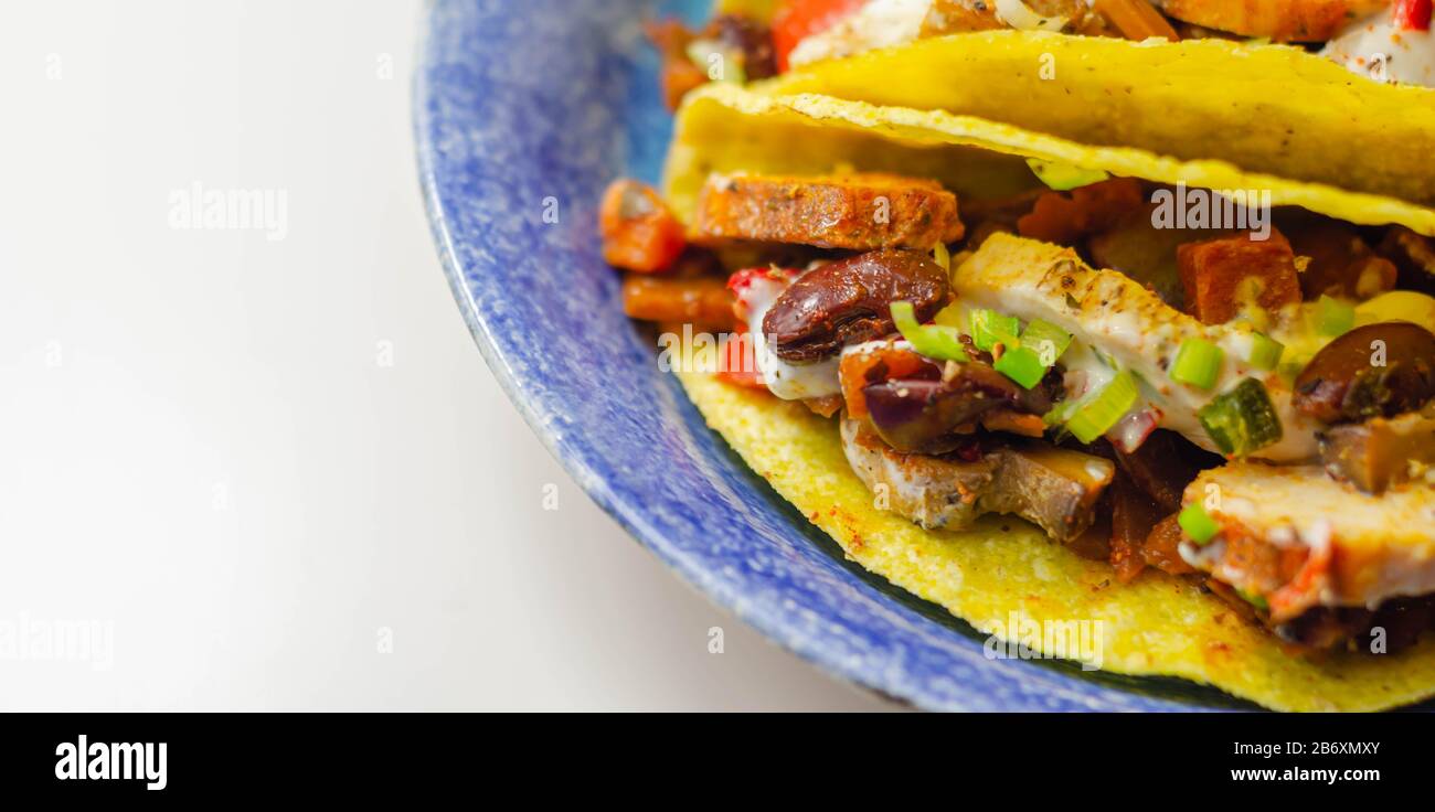 Coquilles de tacos mexicaines avec haricots rouges et de poulet, oignons, poivrons rouges et verts, sauce salsa, nourriture latine Banque D'Images