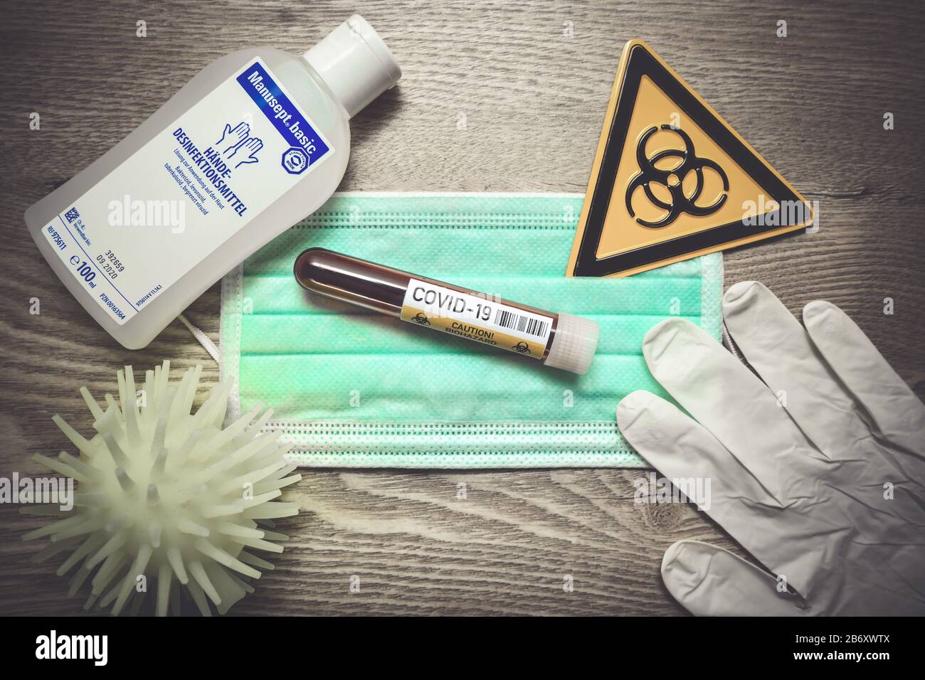 Mundschutz, Blutentnahmeroehrchen, Biogefaehrdungsschild, Schutzhandschuhe und Desinfektionsmittel auf einem Tisch, Symbolfoto Coronavirus Banque D'Images