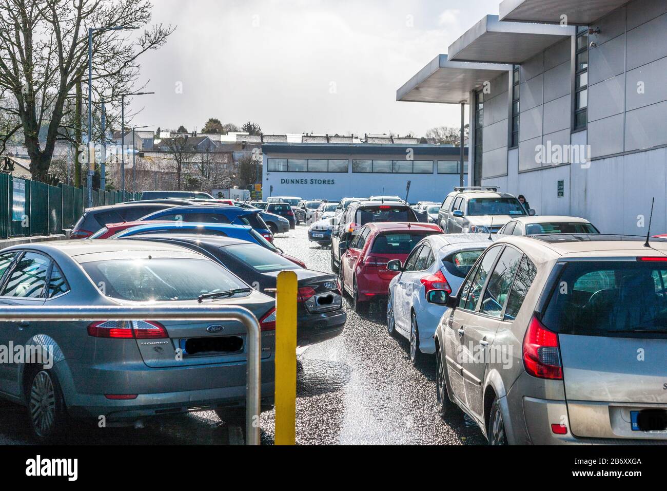 Carrigaline, Cork, Irlande. 12 mars 2020. Dans une heure de l’annonce par le gouvernement irlandais de nouvelles mesures pour lutter contre la propagation de l’épidémie de Covid-19 dans le pays, les files d’attente ont commencé à former des supermarchés extérieurs dans tout le pays. La photo montre les voitures qui attendent d'avoir accès au parking des magasins Dunnes à Carrigaline, Co. Cork, Irlande. - Crédit; David Creedon / Alay Live News Banque D'Images