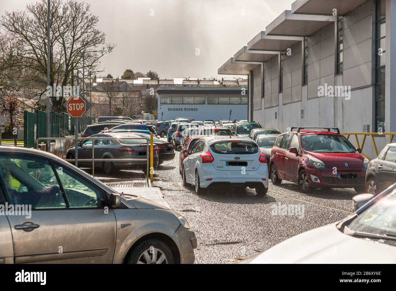 Carrigaline, Cork, Irlande. 12 mars 2020. Dans une heure de l’annonce par le gouvernement irlandais de nouvelles mesures pour lutter contre la propagation de l’épidémie de Covid-19 dans le pays, les files d’attente ont commencé à former des supermarchés extérieurs dans tout le pays. La photo montre les voitures qui attendent d'avoir accès au parking des magasins Dunnes à Carrigaline, Co. Cork, Irlande. - Crédit; David Creedon / Alay Live News Banque D'Images