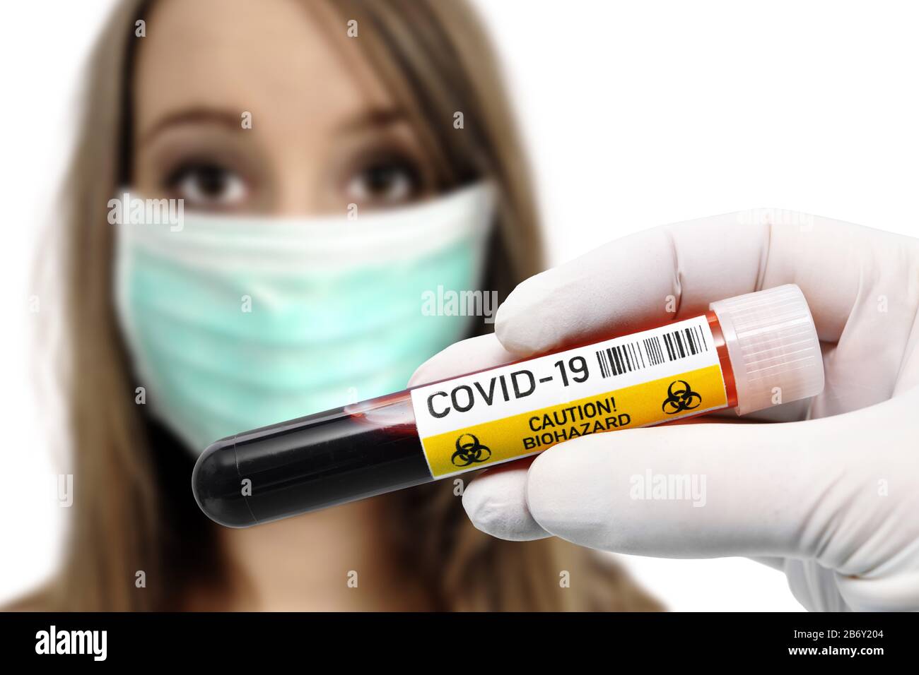 FOTOMONTAGE, Hausen Blutentnahmeroehrchen mit Covid-19-Schriftzug vor Frau mit Atemschutzmaske, Symbolfoto Coronavirus Banque D'Images