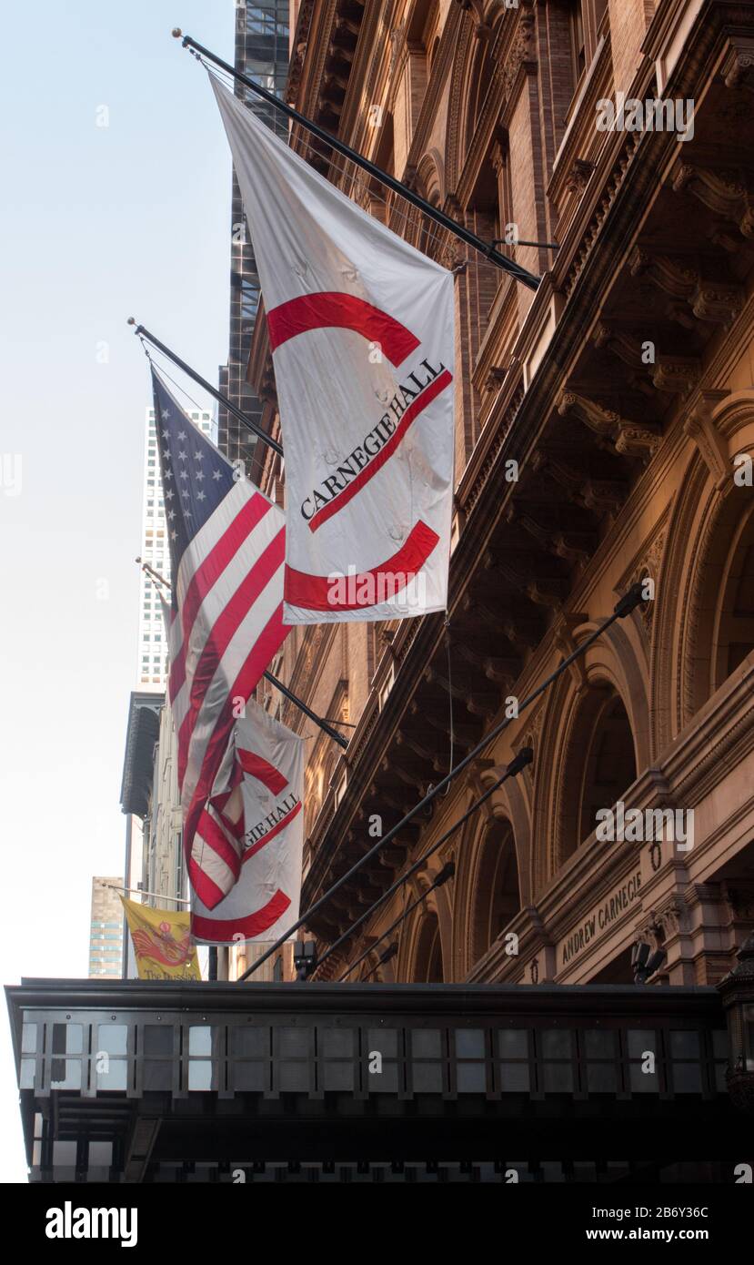 La bannière logo de Carnegie Hall se trouve aux côtés du drapeau américain au-dessus de l'entrée de Carnegie Hall, un monument national américain Banque D'Images