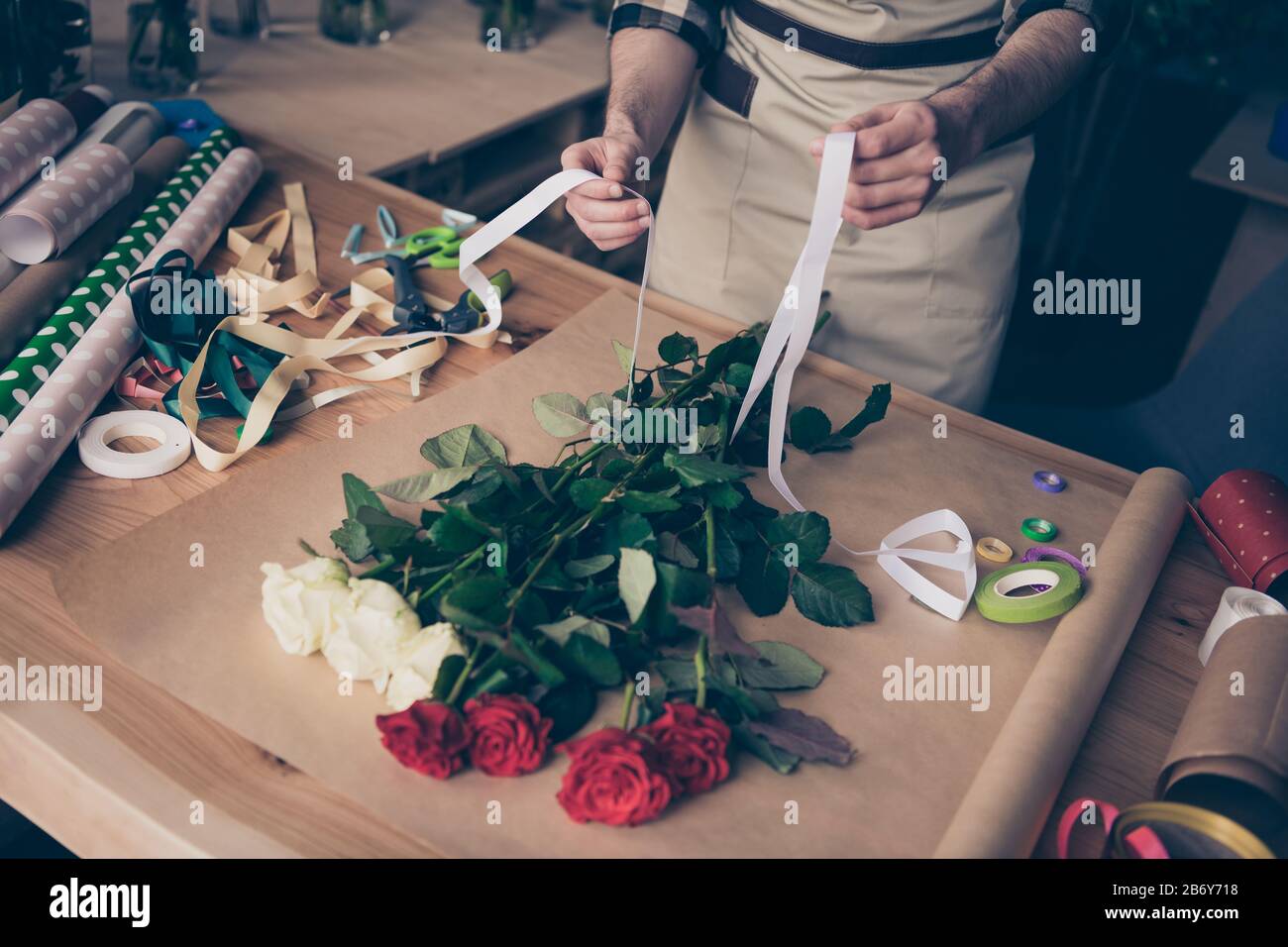 Haut haute angle vue rognée photo de homme gars tenir main prendre le ruban blanc faire assistant surprise serre fleuristry botanique à carreaux chemise Banque D'Images