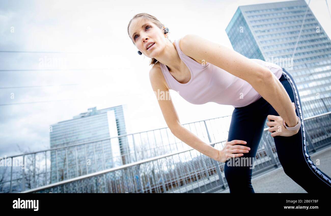 Sportliche Frau fängt ihren Atem nach dem Training. Coureur féminin prenant une pause pendant son jogging. Femme athlète se détendre après l'entraînement Banque D'Images