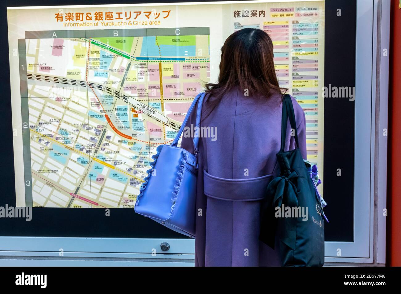 Japon, Honshu, Tokyo, Femme Regardant La Carte De Rue De La Région De Ginza Banque D'Images