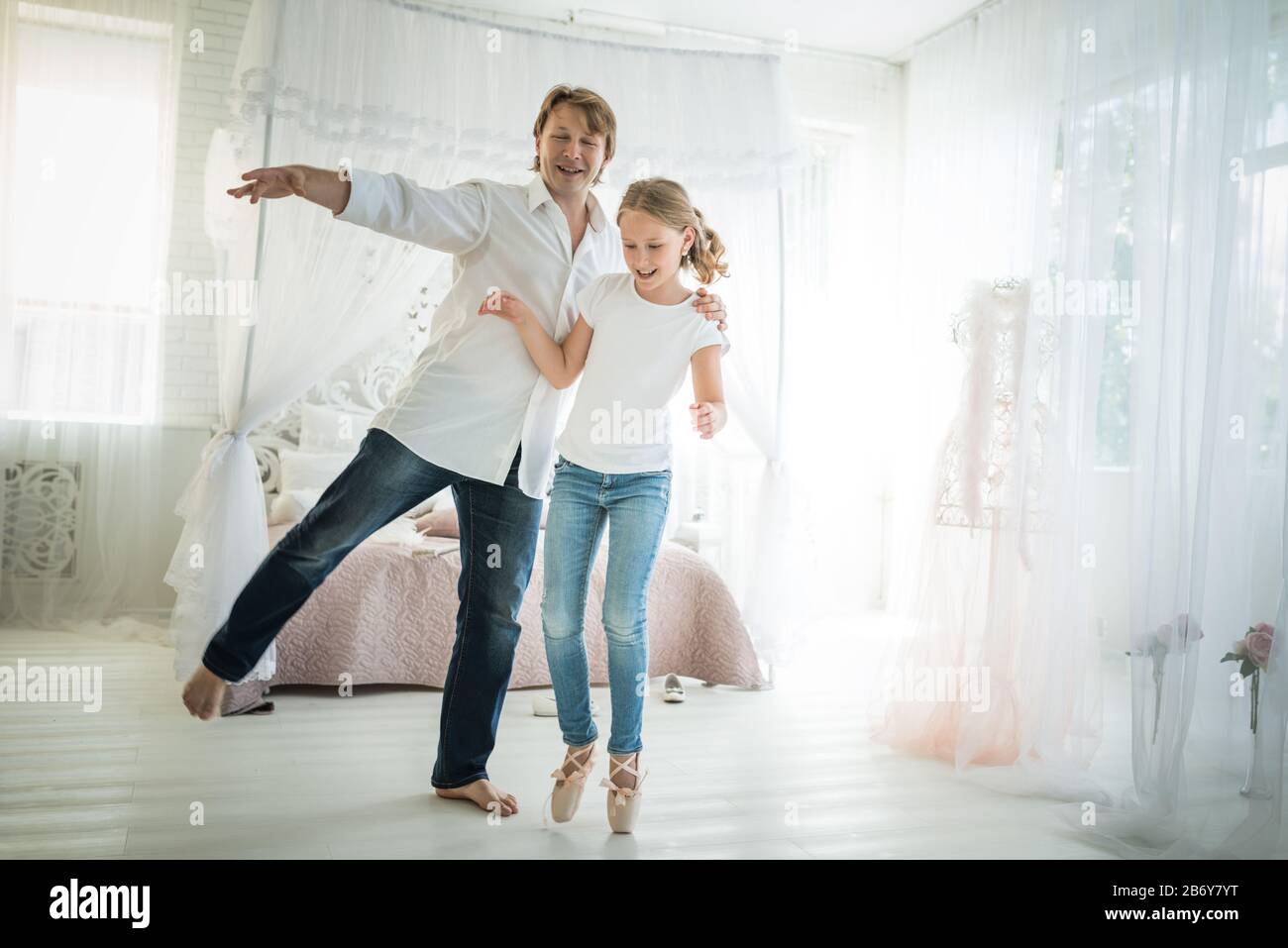 Jeune père fier danse avec sa fille adolescente une ballerine à pointe  chaussures et un Jean debout dans une chambre chic avec un beau intérieur.  Concept Photo Stock - Alamy