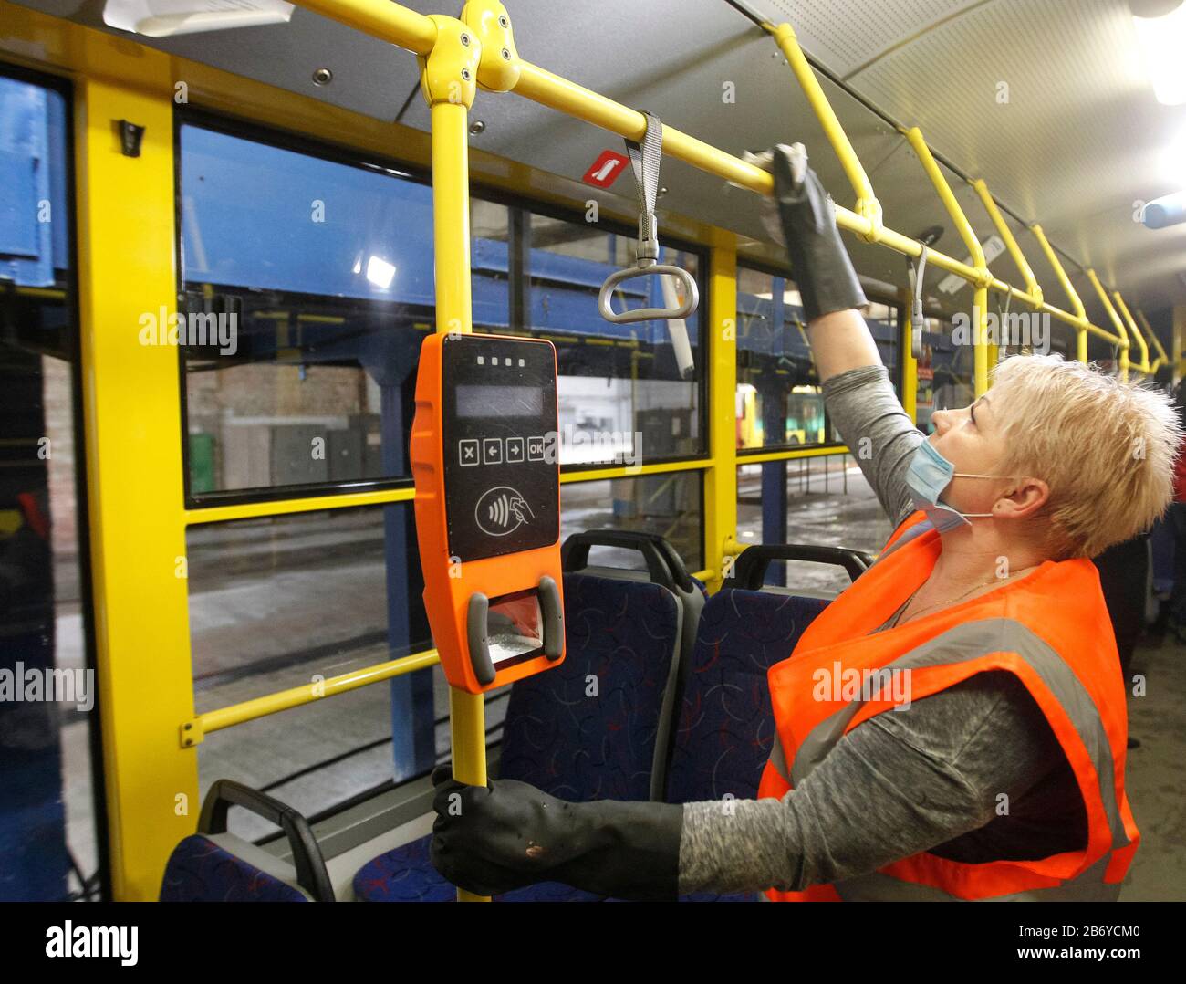 Un travailleur portant un masque de protection désinfecte un autobus de trolley de passagers comme mesure préventive contre le coronavirus COVID-19 dans un dépôt de trolleybus.Du 12 mars au 3 avril 2020, l'Ukraine introduit une quarantaine de trois semaines pour contrer le nouveau coronavirus COVID-19, en raison de l'épidémie mondiale de coronavirus ?ovid-19. La quarantaine en Ukraine prévoit la fermeture des établissements d'enseignement, l'interdiction des rassemblements de masse de plus de 200 personnes, la fermeture des services aériens avec certains pays. L'Organisation mondiale de la santé a déclaré le coronavirus une pandémie mondiale le 11 mars 2020. Banque D'Images