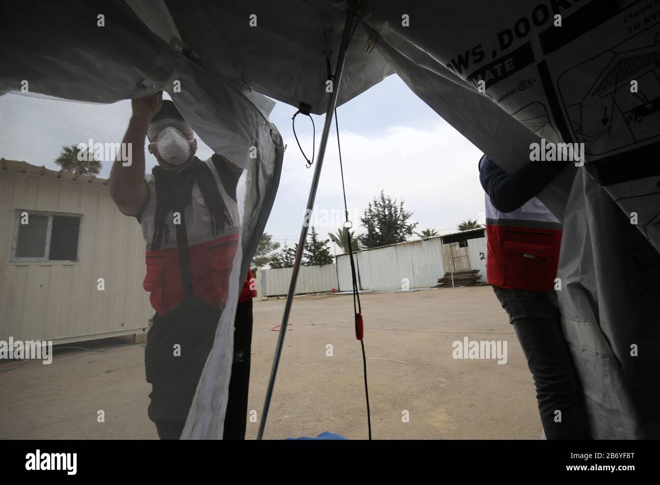 Les travailleurs palestiniens ont installé des tentes pour l'examen médical du virus Corona au passage de Rafah en Égypte, dans la bande de Gaza, le 12 mars 2020. Banque D'Images