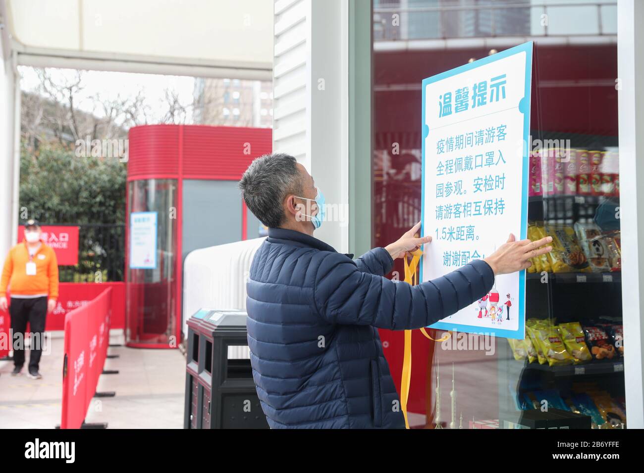 Shanghai. 12 mars 2020. Un membre du personnel affiche des informations sur les réductions de billets à l'entrée de la tour des perles orientales de Shanghai, dans l'est de la Chine, le 12 mars 2020. La tour de Shanghai, le bâtiment le plus élevé de Chine, a rouvert son attraction touristique « Top of Shanghai Observatory » à partir de jeudi. Deux autres sites touristiques ont également commencé à recevoir des touristes de jeudi, dont la tour des perles orientales de Shanghai et la tour Jinmao de Shanghai. POUR ALLER AVEC les paysages de gratte-ciel de 'Hanghai, les monuments à rouvrir' crédit: Ding Ting/Xinhua/Alay Live News Banque D'Images