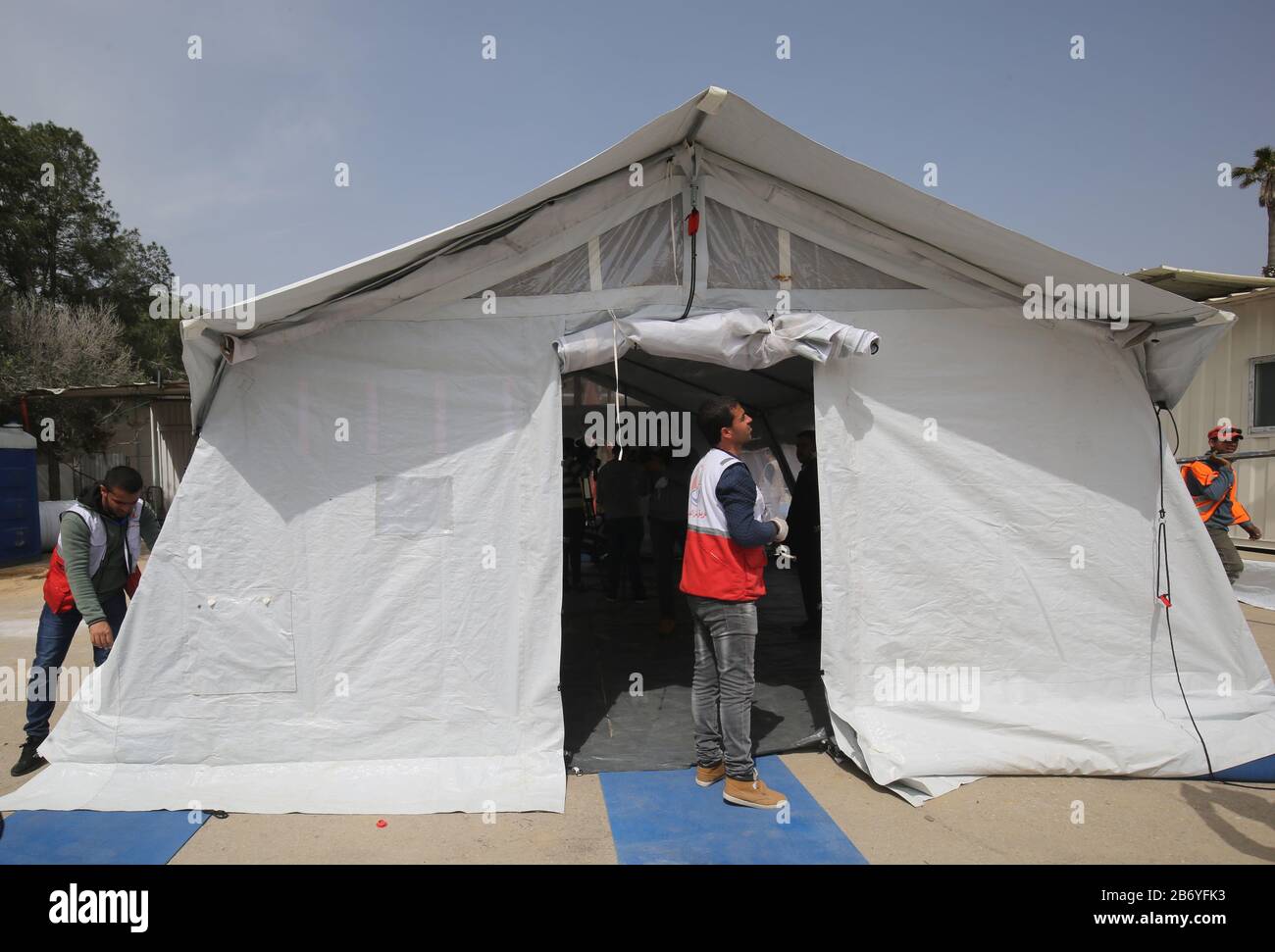 Les travailleurs palestiniens ont installé des tentes pour l'examen médical du virus Corona au passage de Rafah en Égypte, dans la bande de Gaza, le 12 mars 2020. Banque D'Images