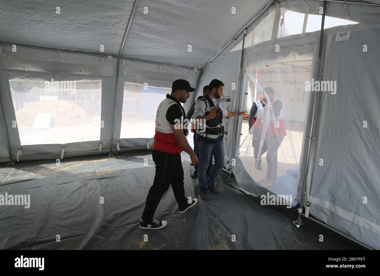 Les travailleurs palestiniens ont installé des tentes pour l'examen médical du virus Corona au passage de Rafah en Égypte, dans la bande de Gaza, le 12 mars 2020. Banque D'Images