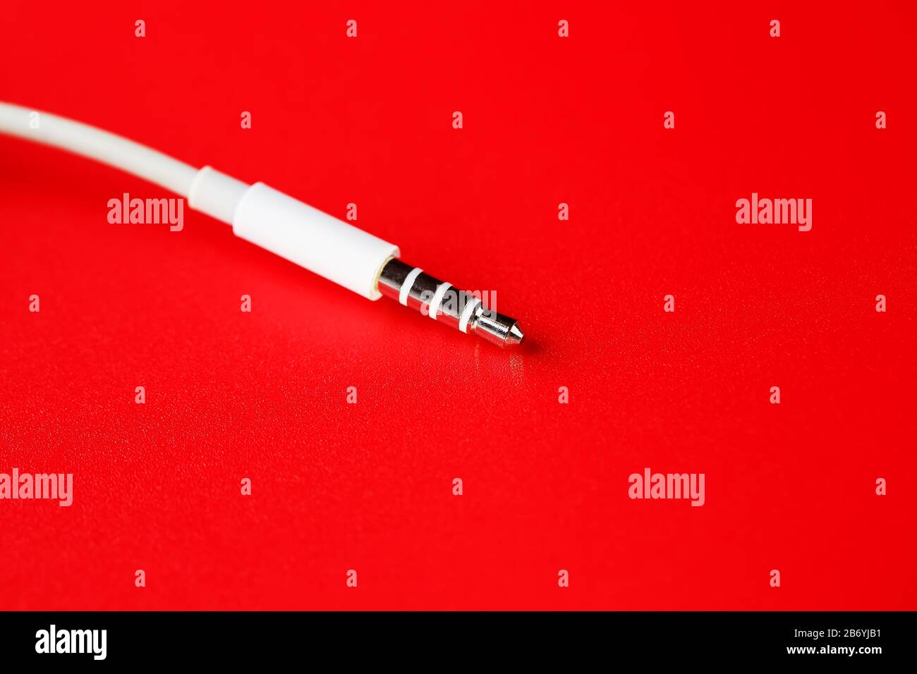 Connecteur blanc câble blanc auxiliaire sur fond rouge Banque D'Images