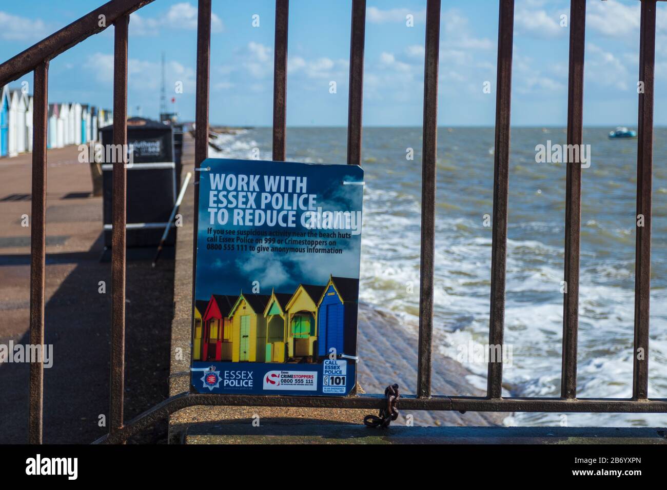 Panneau Coloré Attaché Aux Rampes De La Police D'Essex Encourageant Les Gens À Signaler Le Crime De Beach Hut Sur Le Front De Mer À Thorpe Bay Essex Sur L'Estuaire De La Tamise Banque D'Images