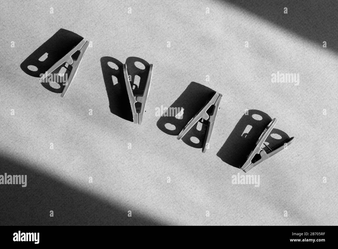 Noir minimaliste de quatre Clothespins sur papier sombre, concept de minimalisme noir Banque D'Images