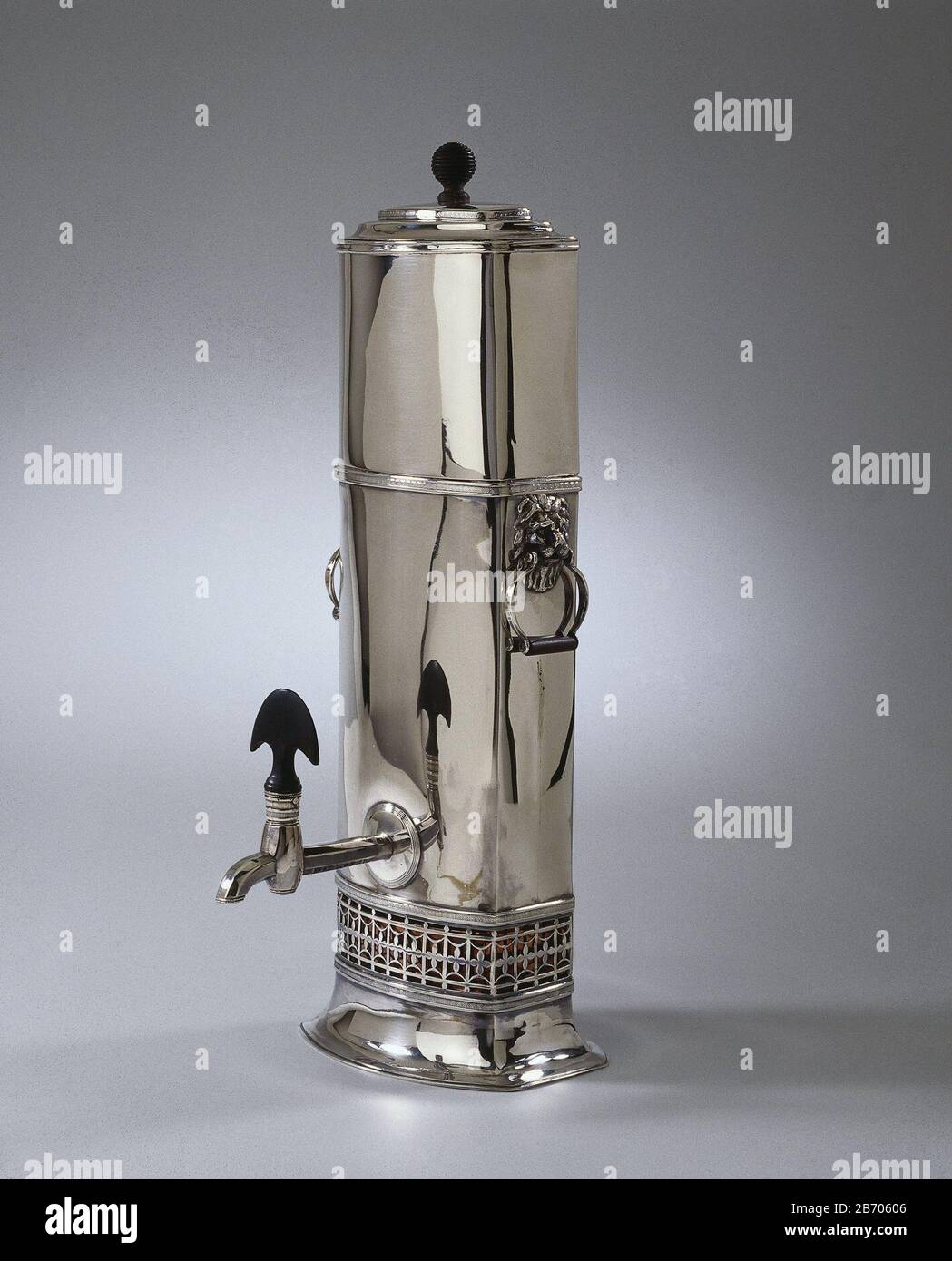 Koffiefilterkan Koffiefilterkan, rechthoekig met licht gebolde voor- en achterzijde en gewelfde base. Aan smalle zijden een leeuwenmasker met beugelvormig hengsel met houten greep à de muil. De gefacetteerde kraan heeft een tonvormig gedeelte met draaibaar afsluitstuk, versierd met een geribde- en een parelrand, bekroond porte een padestoel-vormig handvat.de kan is aan onderzijde opengerkt met een patroon van spijlen Banque D'Images