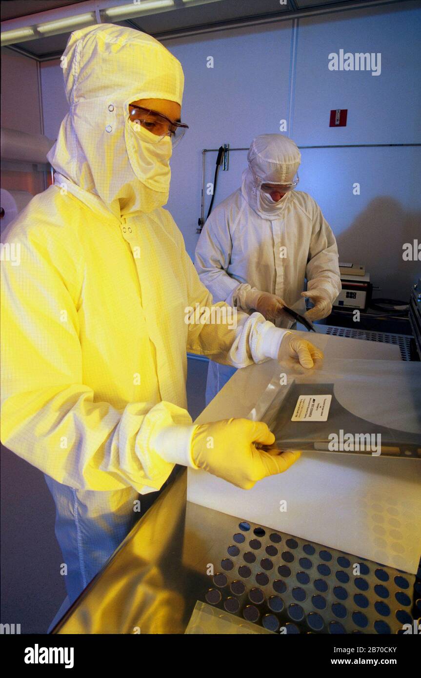 Austin Texas USA, 1998: Les travailleurs portant des costumes de lapin sac des composants d'ordinateur dans la salle blanche d'une entreprise de haute technologie d'Austin. ©Bob Daemmrich Banque D'Images