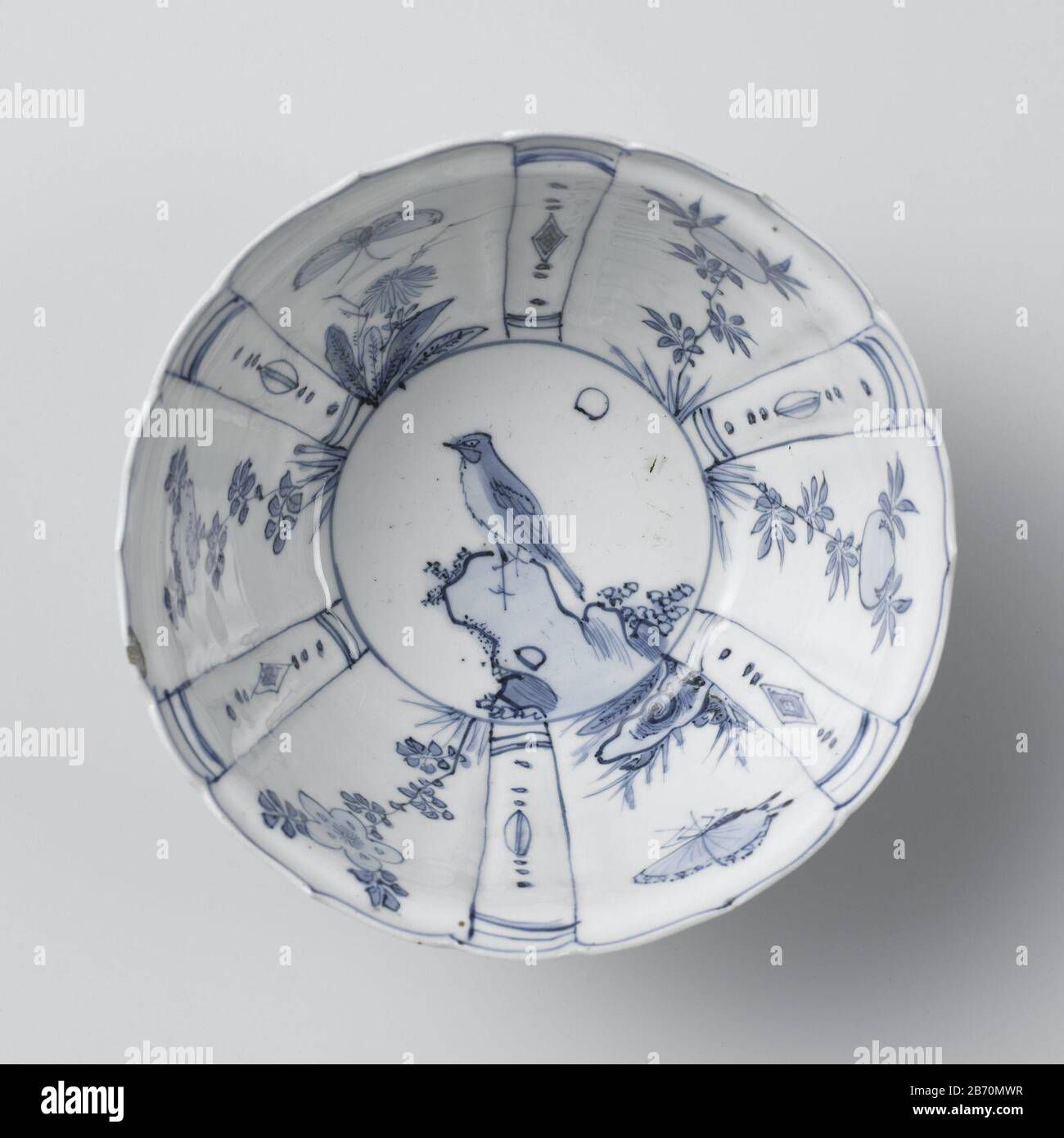 Kraaikop Kraaikop a rencontré les dames chinoises, bomen en een vogel op een perrots Kom de kraaikop van porselein met een geschulpte rand, beschilderd dans onderglaruur blauw. De buitenwand est verdeeld à brede en smalle vakken rencontré à de brede vakken afwisselend een zittende Chinese dame op een omheind teras de met een boom (bananenplant, wilg). Dans de smalle vakken strikken en een ruyi-motief. Op de bodem een vogel op een pourriture. In de brede vakken op de binnenwand een vlinder bij een padenstoel de een chrysante, de met een bloemrak. De smalle vakken met stippen, ruiten en pétrels. Kraakporselein dans blauw-wit. Ma Banque D'Images