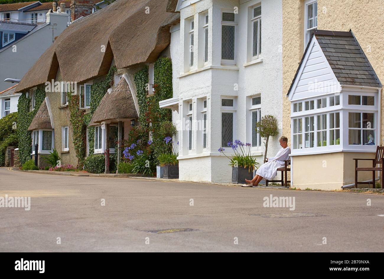 Lady détente en face d'une maison de vacances en bord de mer à Saint-Mawes, au sud de Cornwall Banque D'Images