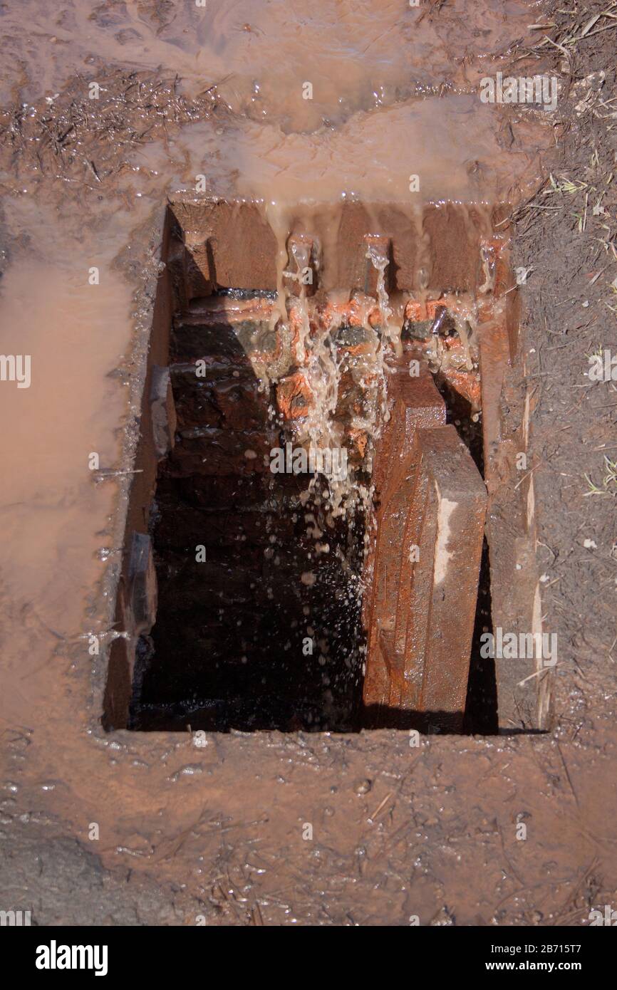 Grille anti-tempête cassée. De l'eau sale et des ordures entrent dans la gouttière. Banque D'Images