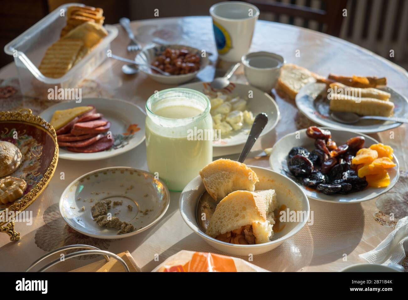 Table à manger non nettoyée avec assiettes, tasses et nourriture. Banque D'Images